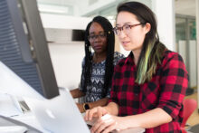 Two women working at a computer